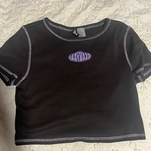 crop top with black and purple stitching with a logo on the front!